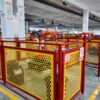 Rows of automated robotic cells with yellow and red safety enclosures streamline efficient, high-precision manufacturing