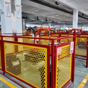 Rows of automated robotic cells with yellow and red safety enclosures streamline efficient, high-precision manufacturing
